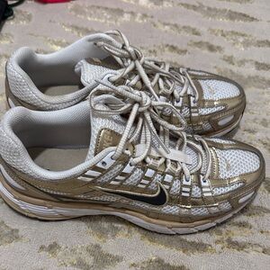 Nike Women’s White and Gold Athletic Sneakers with Black Swoosh